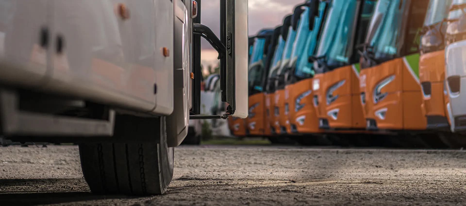 A close-up view of a bus wheel with several busses in the background, highlighting the need for proper maintenance and torque tools.